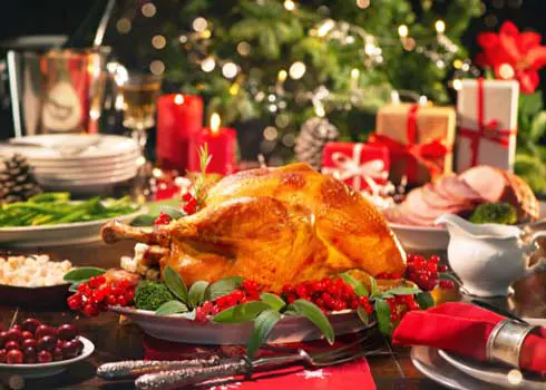 Background Image Showing A Table Set For Christmas Dinner, A Christmas Tree and Gifts