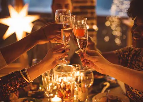 Close Up Of A Group Of Diners Toasting With Champagne Glasses