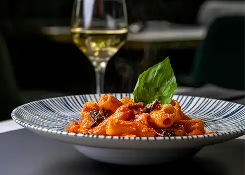 Close Up Of A Plate Of Pasta & A Glass Of Wines